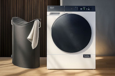Miele wasmachine 9kg vulgewicht naast wasmand, ideaal voor gezinnen en grote wasbeurten