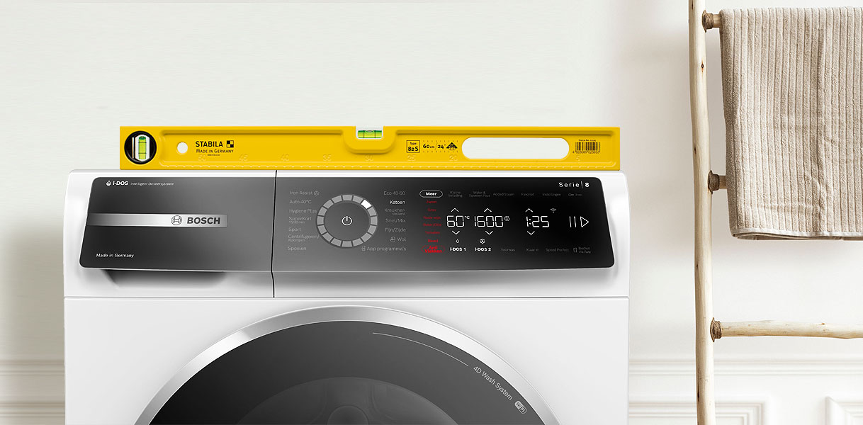 Gele waterpas op Bosch wasmachine om te controleren of deze recht staat