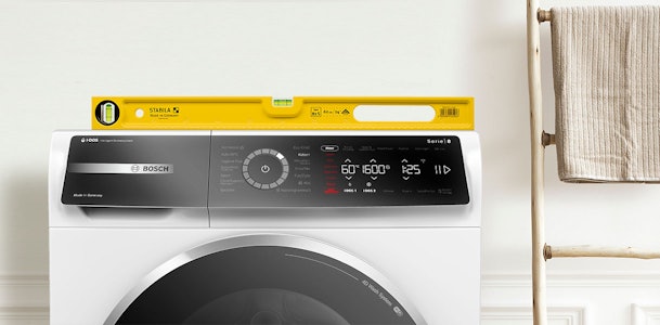 Gele waterpas op Bosch wasmachine om te controleren of deze recht staat