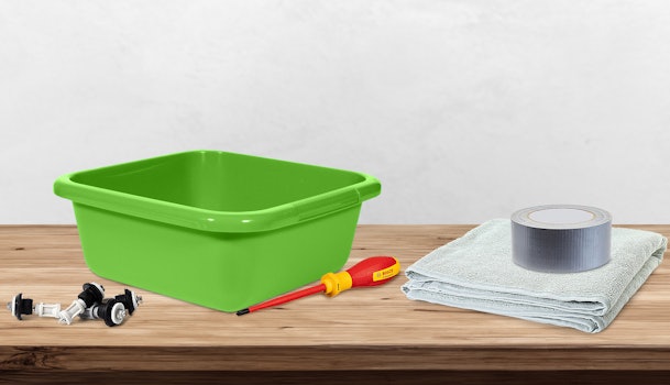 Benodigdheden voor het ontkoppelen van een wasmachine zoals emmer handdoeken ducttape schroevendraaier en transportbouten