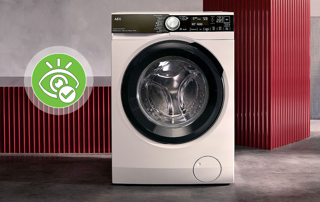 Witte AEG voorlader wasmachine met stoomfunctie tegen een rode achtergrond in een moderne ruimte