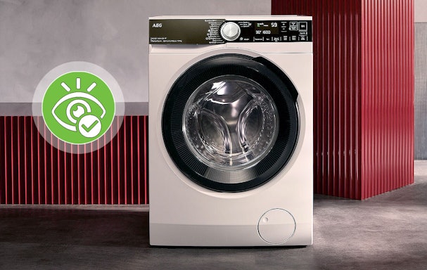 Witte AEG voorlader wasmachine met stoomfunctie tegen een rode achtergrond in een moderne ruimte