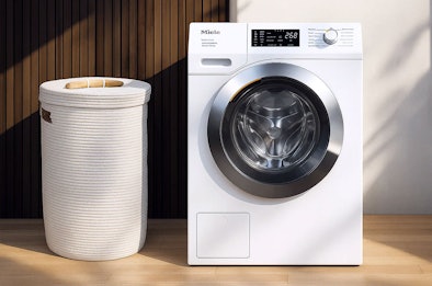 Miele wasmachine 10kg vulgewicht naast wasmand, ideaal voor grote gezinnen en intensief gebruik