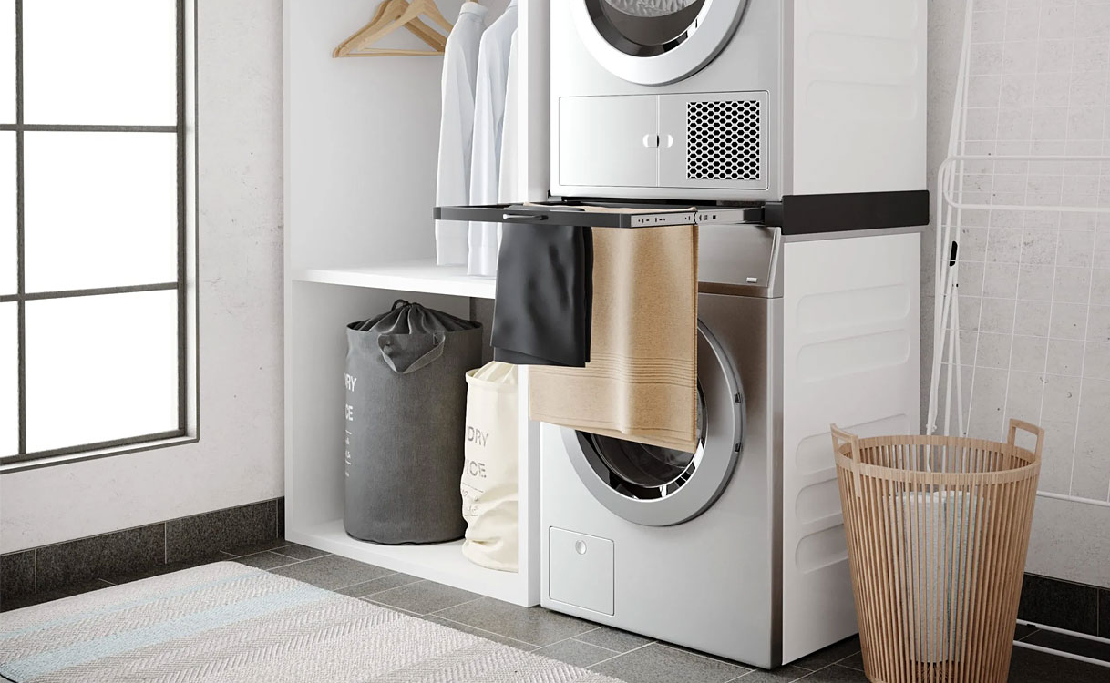Gestapelde wasmachine en droger met uitschuifbaar werkblad, hangplank en waszakken