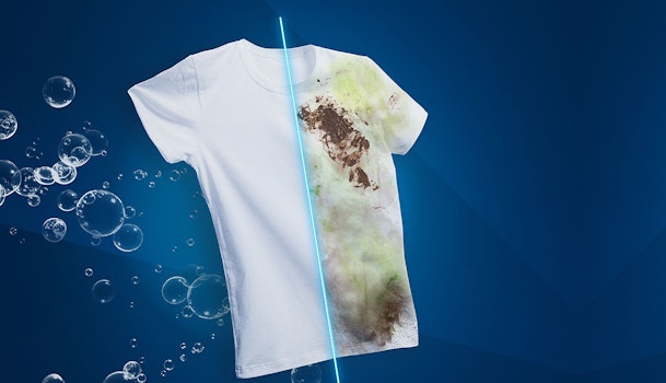 Wit T-shirt met hardnekkige vlek omgeven door waterdruppels die het StainExpert vlekverwijderingsproces visualiseren