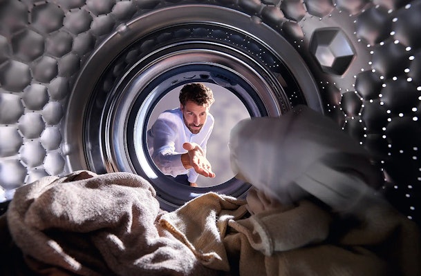 Man voegt wasgoed toe aan Miele wasmachine met AddLoad functie