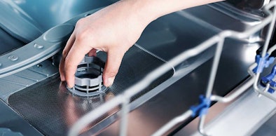 Hand verwijdert filter uit vaatwasser voor wekelijks onderhoud