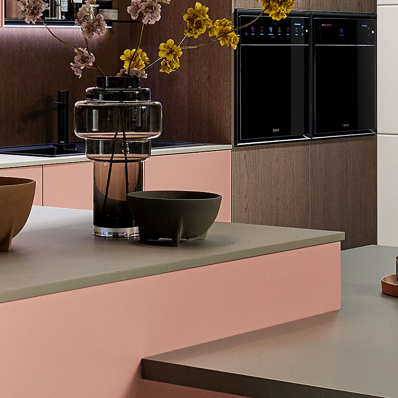 Grijs werkblad detail bij poederroze keuken.