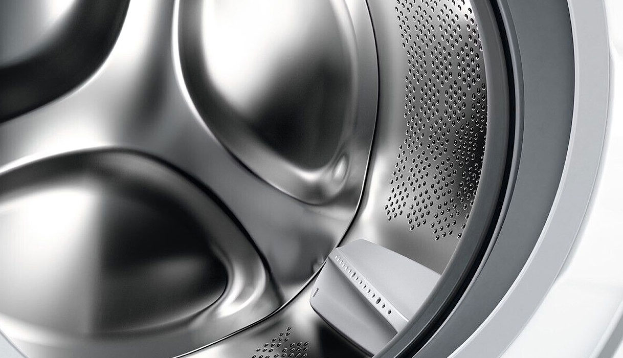 Close-up van wasmachine trommel met kleine gaatjes en afgeronde meenemers
