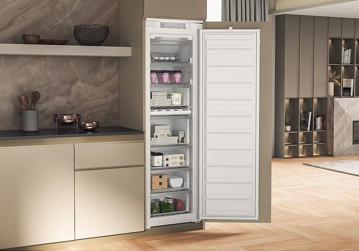 Whirlpool inbouw vriezer volledig geïntegreerd in een moderne keuken met open deur en gevulde laden