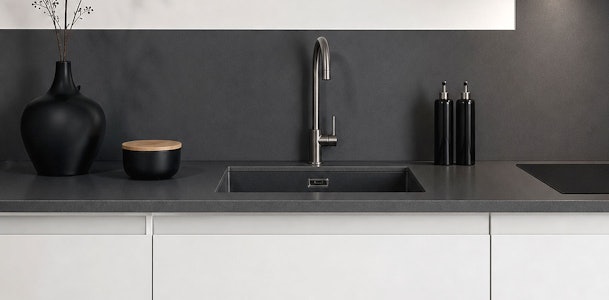 Witte strakke keuken met composiet werkblad, spoelbak en zwarte decoratie