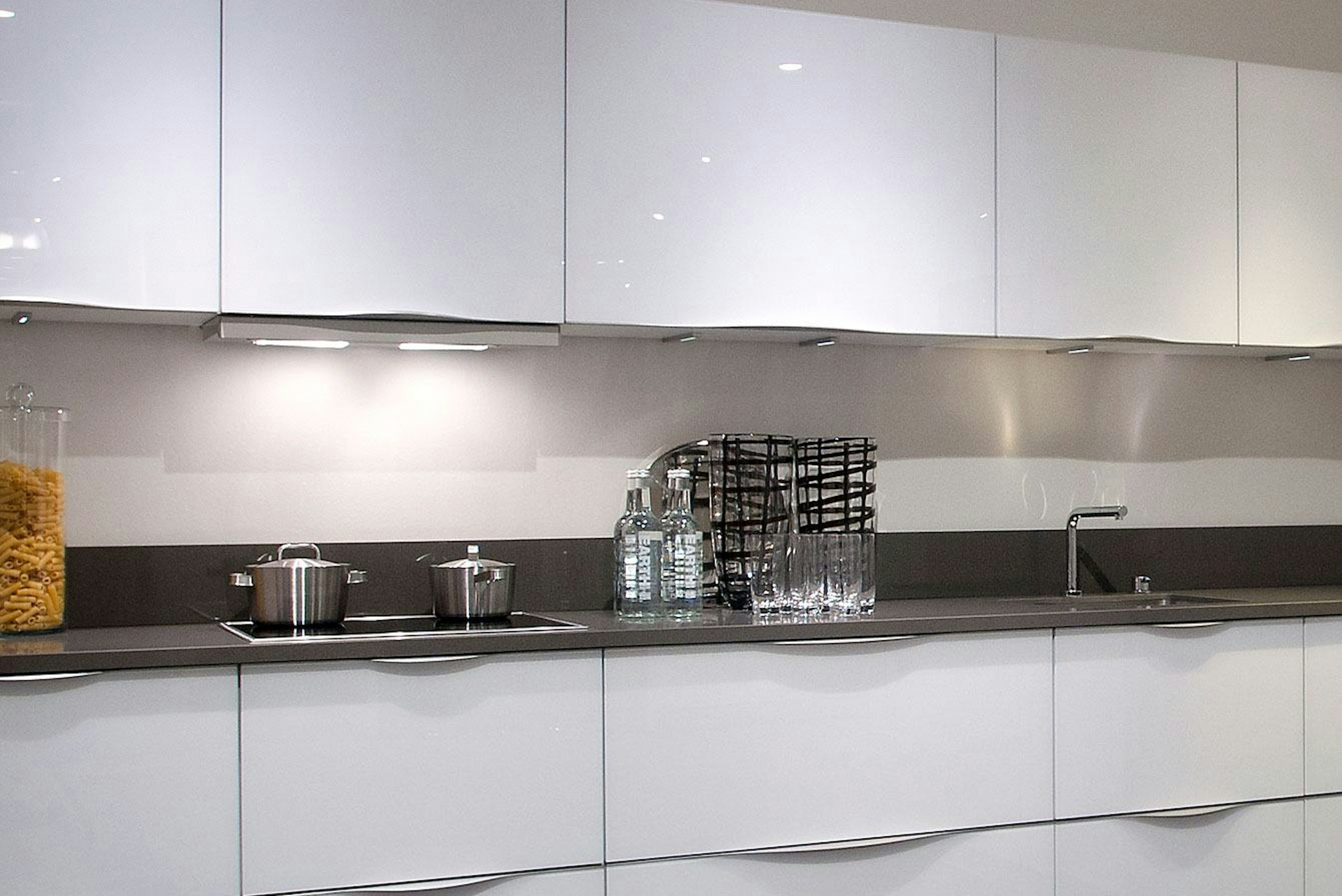 Witte design keuken met kastenwand in hoogglans
