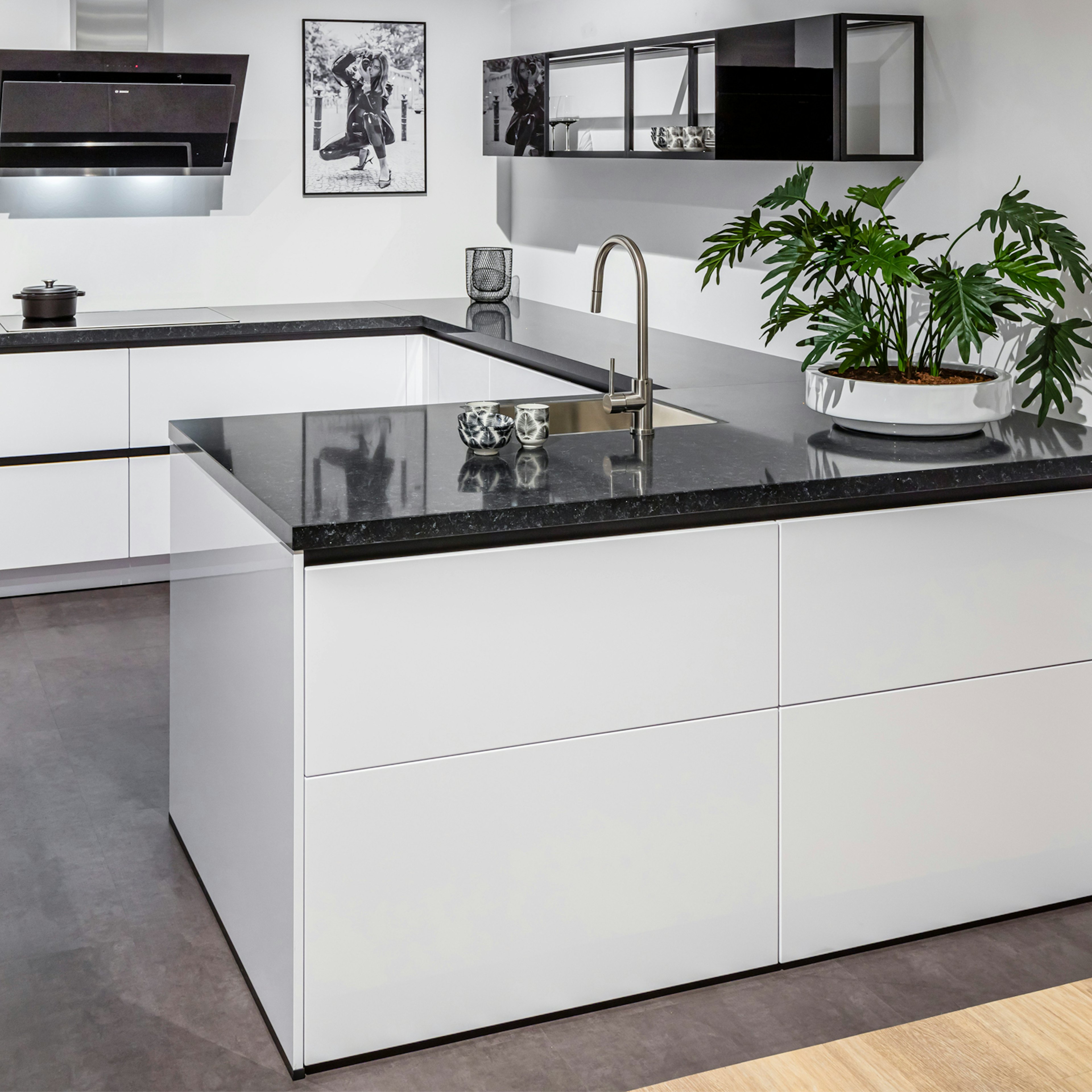 Witte greeploze keuken met zwart granieten werkblad