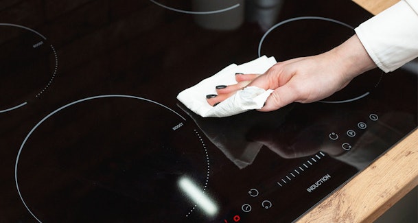 Witte waas van inductie kookplaat verwijderen met keukenpapier