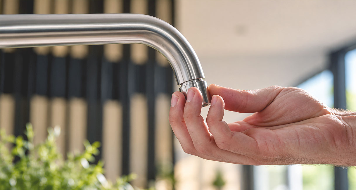 Zeefje met de hand uit de uitloop van keukenkraan draaien om kalk te verwijderen