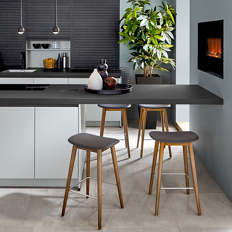 Zitbar met donker werkblad en houten barkrukken.