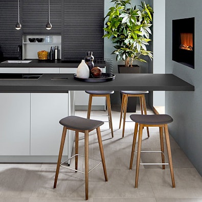 Zitbar met donker werkblad en houten barkrukken.