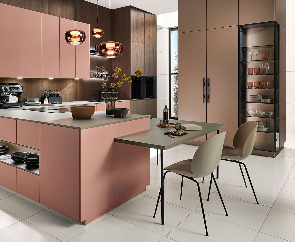 Moderne keuken met kookeiland en geïntegreerd zitgedeelte op eettafelhoogte met twee stoelen, uitgevoerd in zachte roze en houttinten