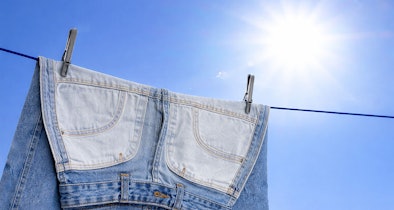Jeans drogen aan waslijn buiten met zonlicht voor sneller drogen zonder droger