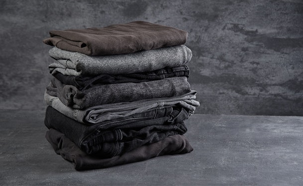 Zwarte en donkere kleding netjes opgestapeld voor het wassen