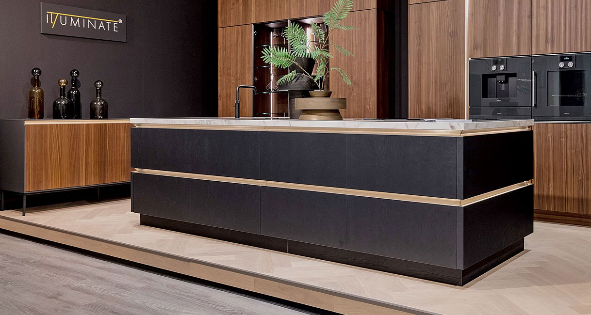 Zwart kookeiland met greeploze fronten en licht werkblad in luxe showroomkeuken