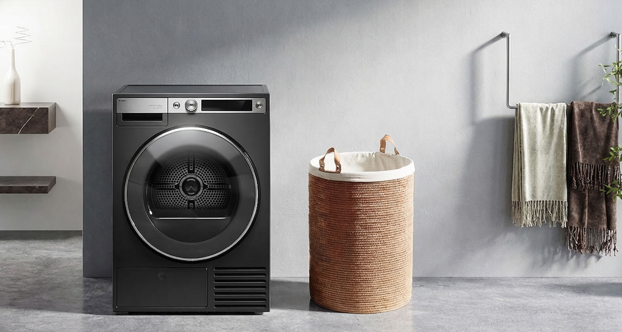 Zwarte droger in moderne wasruimte gecombineerd met betonnen muur en gevlochten wasmand