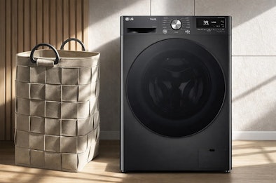 Zwarte LG wasmachine met ThinQ bediening naast een gevlochten wasmand