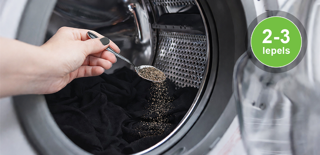 Gemalen zwarte peper wordt toegevoegd aan de wastrommel bij het wassen van zwarte kleding