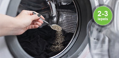 Gemalen zwarte peper wordt toegevoegd aan de wastrommel bij het wassen van zwarte kleding