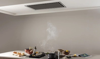 Zwarte plafondunit boven een kookeiland.