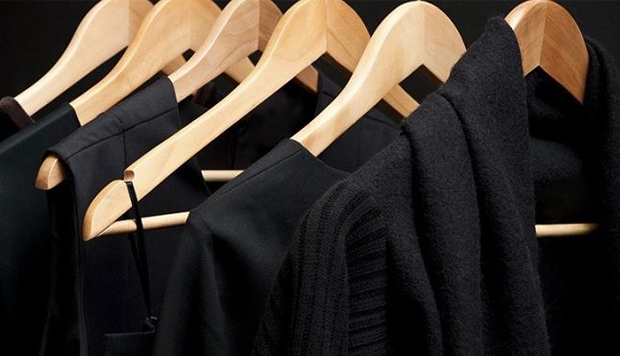 Zwarte kleding hangt schoon en netjes uit op houten hangers na het wassen