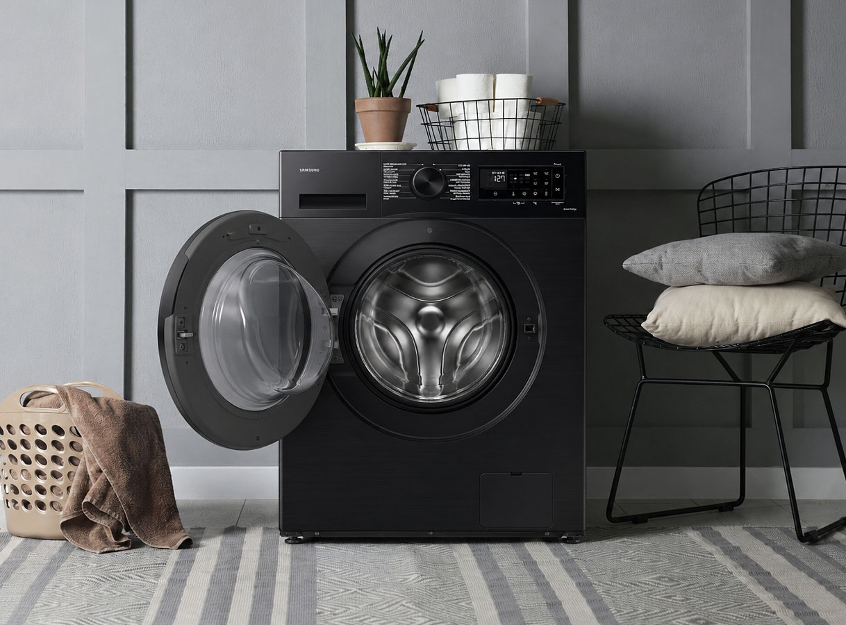 Zwarte voorlader wasmachine in moderne wasruimte met open deur en stijlvolle matte afwerking.
