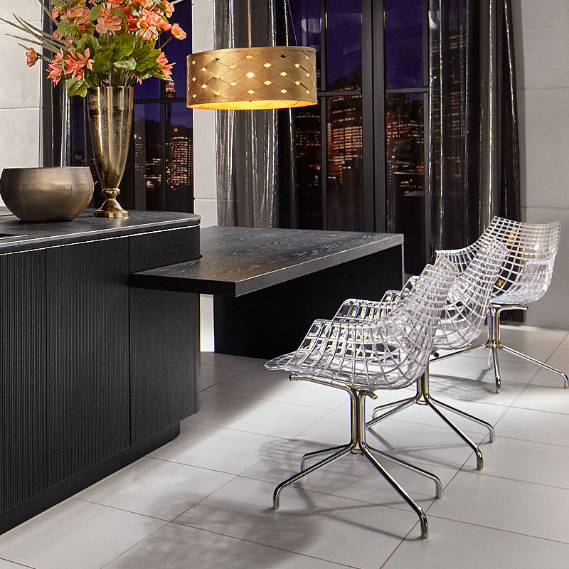 Verlengd donker blad als bargedeelte met drie transparante stoelen.