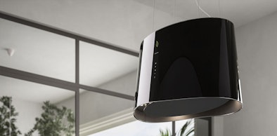 Zwevende afzuigkap met dunne kabelophanging als designstatement in een lichte keuken